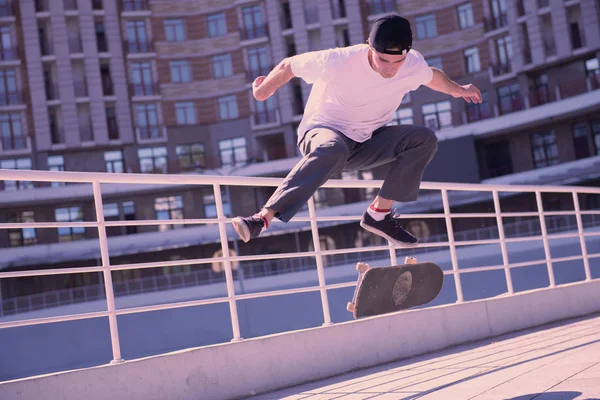 Aktive männliche Person versucht, auf Skateboard zu springen — Stockfoto