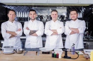 Bir mutfak ortasında duran aşçıların büyük takım