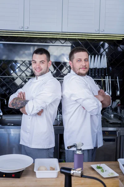 Hombres guapos parados en medio de una cocina —  Fotos de Stock