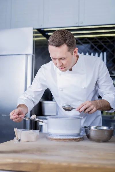 Cocinero joven inventando un nuevo plato para un menú —  Fotos de Stock