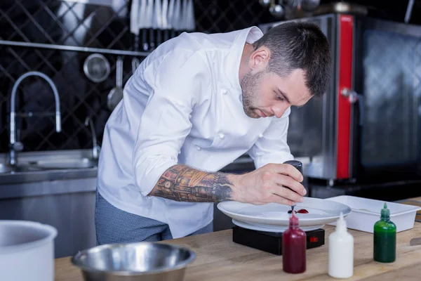 Chef guapo cocinando algo inusual y delicioso — Foto de Stock