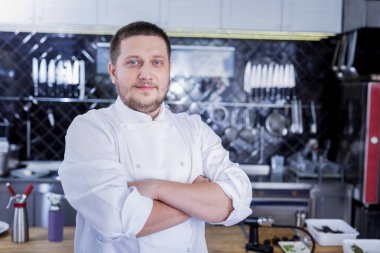 Mutfak ortasında duran hoş güzel aşçı