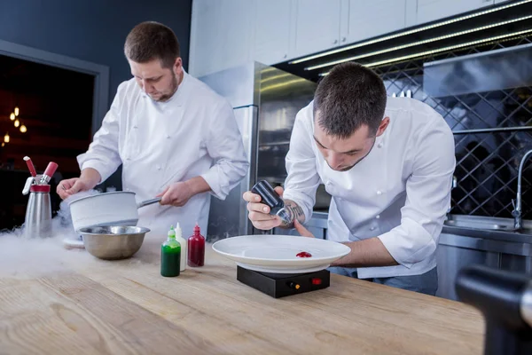 Cocineros que trabajan duro preparando muchos platos diferentes —  Fotos de Stock