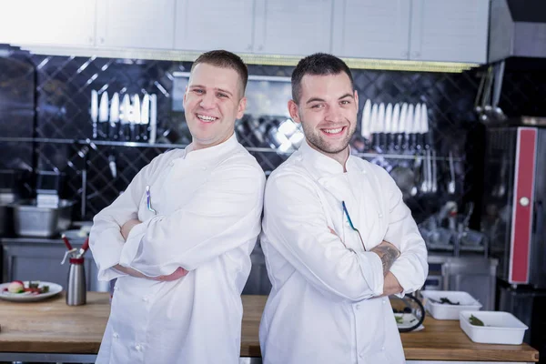 Smiling cocineros posando en la cocina juntos —  Fotos de Stock