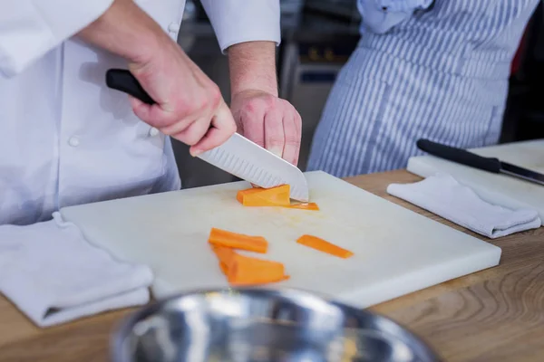 Cocinero experimentado cortando ingredientes para un plato —  Fotos de Stock