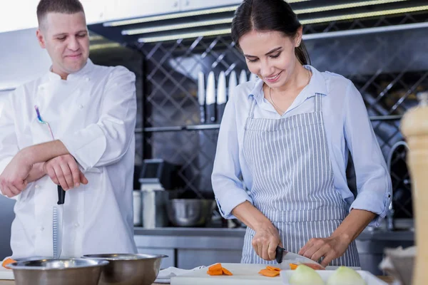 Attraktive Frau kocht ein neues Gericht in der Küche — Stockfoto