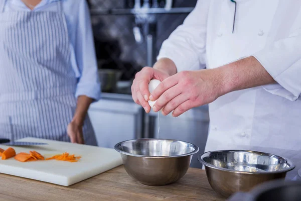 Kendine güvenen aşçı yemek için yeni malzemeler ekleme — Stok fotoğraf