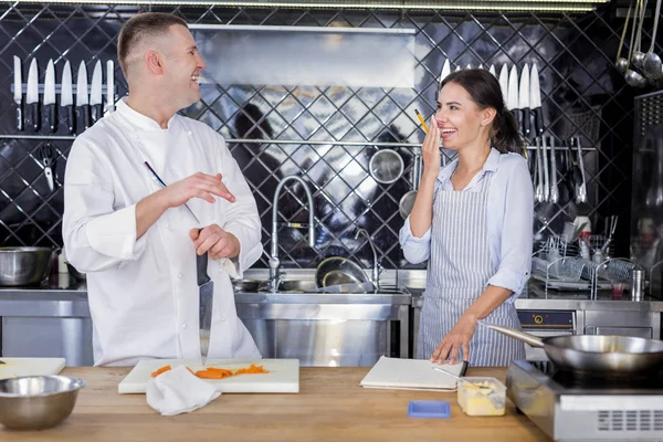 Alegre cocineros riendo en la cocina juntos —  Fotos de Stock