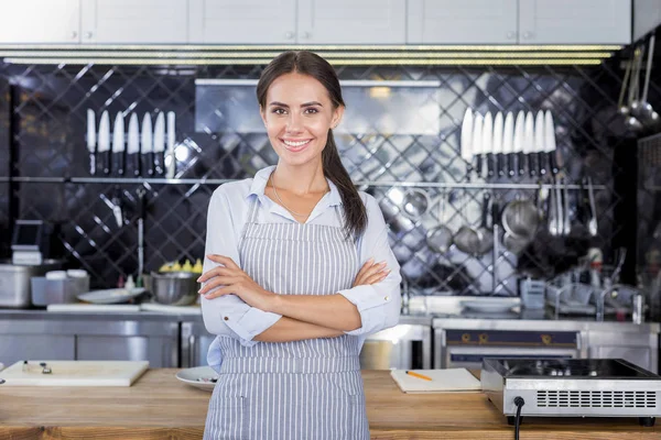 Mujer morena de pie en medio de una cocina —  Fotos de Stock