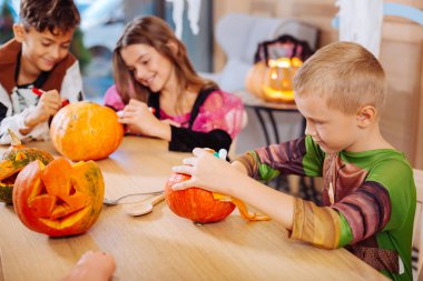 Cadılar Bayramı'nda kabak dekorasyon Ninja kaplumbağa kostümü giymiş sarışın çocuk