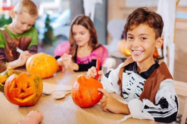 Çocuk giyen iskelet kostüm şaşırtıcı Halloween duygu için kabak boyama