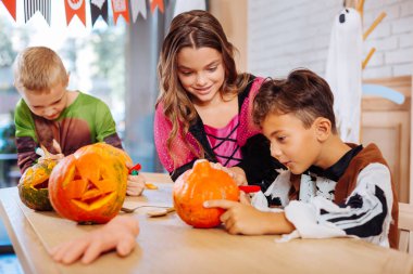 Üç çocuk Cadılar Bayramı aile partisi için hazırlanıyor süre kabaklar dekorasyon