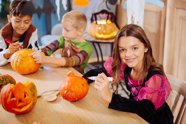 Τρία παιδιά αίσθημα περιλήφθεία στη διακόσμηση των κολοκύθες για το Halloween πάρτι — Φωτογραφία Αρχείου
