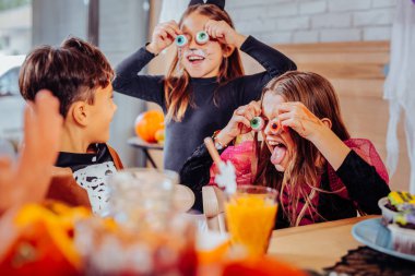 Halloween parti kostümleri giyen boyalı yüzü olan üç çocuk