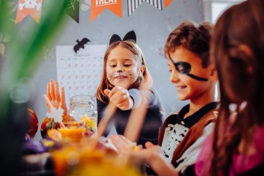 Çocukları eğlendirmek ve hayret Cadılar Bayramı kutlama duygu boyalı yüzler ile