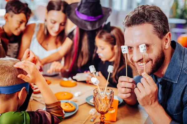 Bearded father holding marshmallows on sticks while celebrating Halloween — Stock Photo, Image