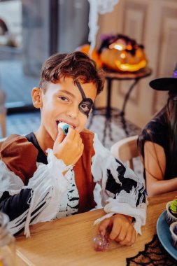 Eğlenin çocuk. Sakızlı şeker Cadılar Bayramı için arkadaşları ile yerken duygu şirin komik okul çocuğu ağırladı