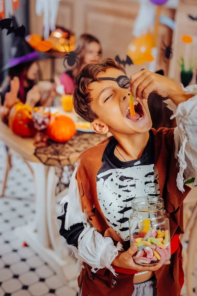 Cute schoolboy wearing nice pirate costume while attending Halloween party