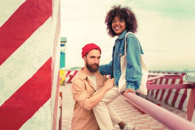 Yakışıklı adam el demiryolu üzerinde oturan kız arkadaşı ise kendinden emin bakan