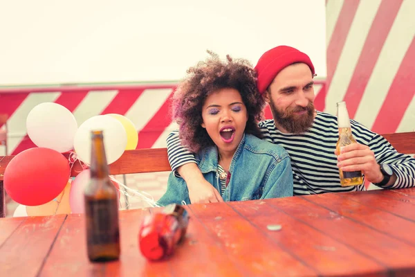 Donna assonnata sbadiglia mentre l'uomo felice guarda la birra — Foto Stock