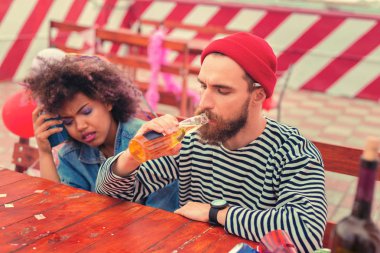 Yorgun adam bira ve kız arkadaşı şişe başına koyarak içme