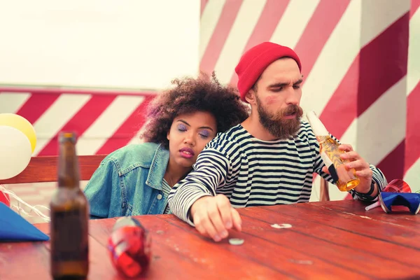 Sleepy man drinking beer after having tiresome party