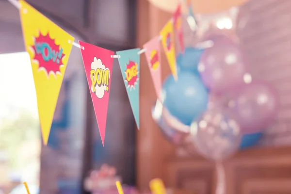 Colorful triangle party flags placed in the room before birthday party