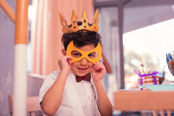 Careful boy wearing yellow mask while being at the carnival — Stock Photo, Image