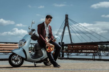 Motosiklet yakınındaki kız için bekleyen sakin kendinden emin adam