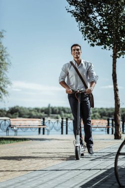 Neşeli neşeli adam scooter üzerinde street aşağı sürme