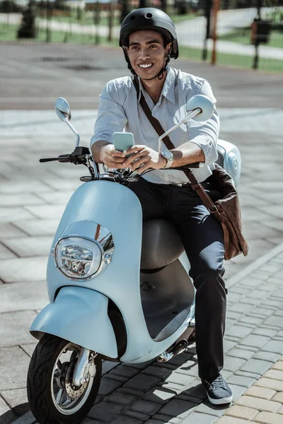 Glücklicher männlicher Student wartet auf Anruf auf Motorrad — Stockfoto