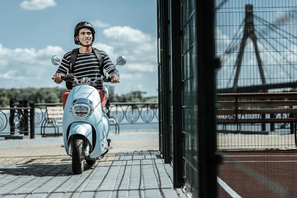 Aufmerksamer fröhlicher Kerl mit Freunden auf Motorrad — Stockfoto