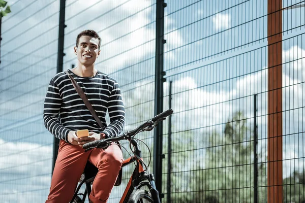 Merry happy guy checking weather on bicycle — Stok Foto