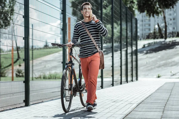 Chico positivo alegre acercándose a destino en bicicleta — Foto de Stock