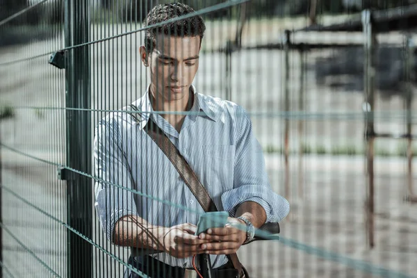 Fokuserade eftertänksam kille öppning meddelande på telefon — Stockfoto