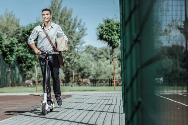Glad male courier delivering package on scooter — Stock Photo, Image
