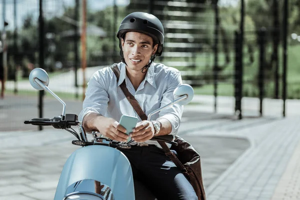 Pensive pleasant guy rethinking replay on motorbike — Stock Photo, Image