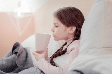 Küçük kız yatakta çay içme profili