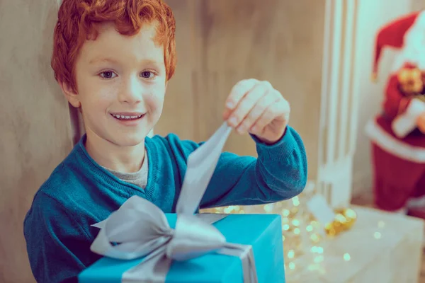 Веселый ребенок открывает подарочную коробку — стоковое фото