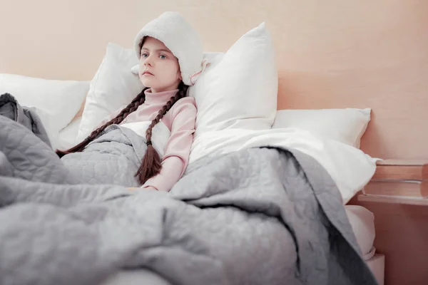 Sick emotionless girl lying in bed — Stock Photo, Image