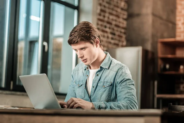 Hombre agradable inteligente mirando la pantalla del ordenador portátil — Foto de Stock