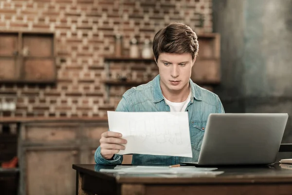 Un hombre serio e inteligente sosteniendo un plano — Foto de Stock