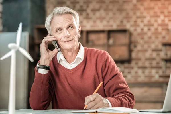 Agradable hombre encantado sosteniendo su teléfono inteligente — Foto de Stock