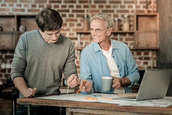 Hombre de edad positiva que trabaja con su estudiante — Foto de Stock