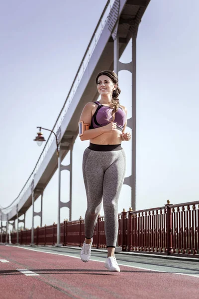 Radostnou pozitivní žena běží na mostě — Stock fotografie
