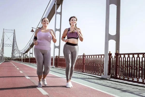Güzel pozitif kadın birlikte köprüde koşu — Stok fotoğraf