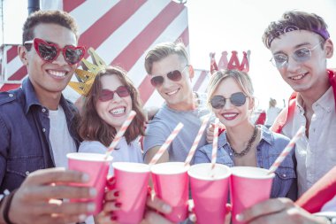 Onların pembe bardak fotoğraf makinesinde gösteren neşeli öğrenciler