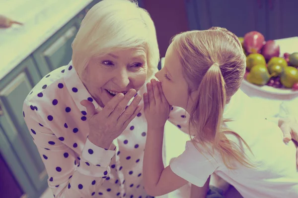 Glückliche Oma hört auf Geheimnis ihrer Enkelin — Stockfoto