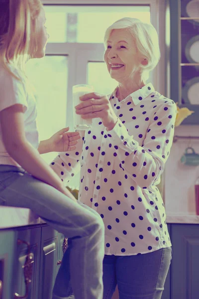 Positieve blij blonde vrouw die houdt van glas melk — Stockfoto