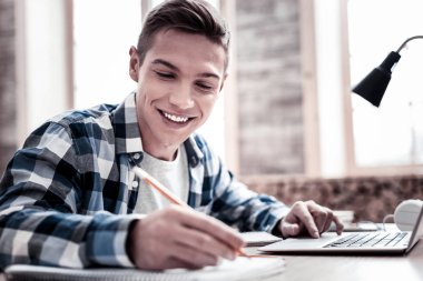 Notlar yaparken neşeli öğrenci eğitim ve sahip iyi bir ruh hali